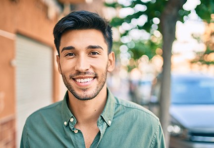 A smiling Latin man walking in the city