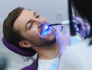 A male patient receiving tooth-colored fillings from his dentist