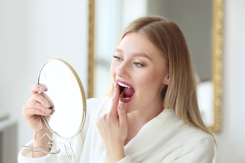 Patient checking their dental crown in the mirror